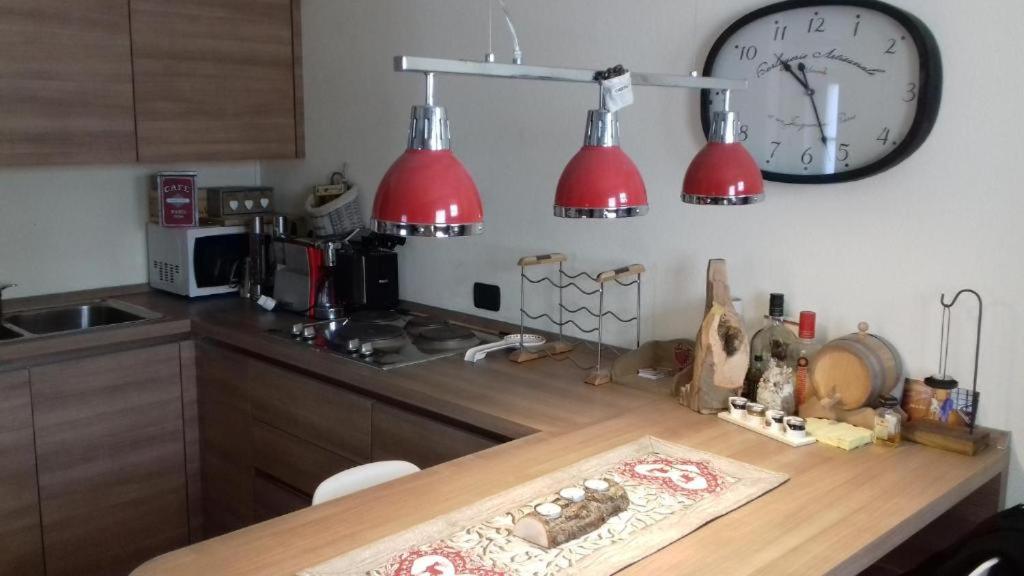 kuchnia z dwoma czerwonymi światłami i zegarem na ścianie w obiekcie Love chalet w Livigno