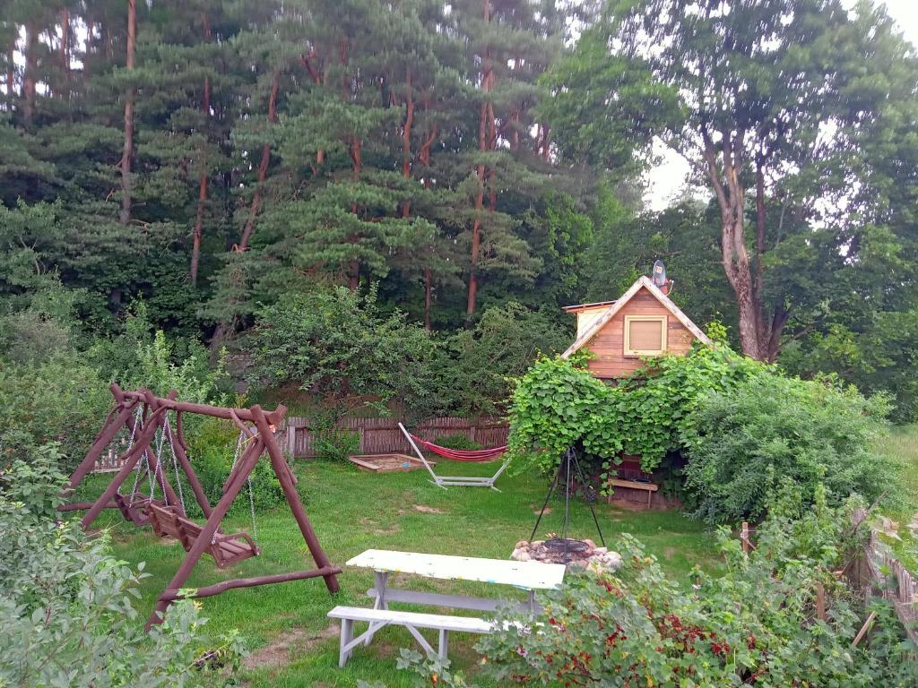 un jardín con un banco y un columpio y una casa en Gajóweczka, en Jałowo