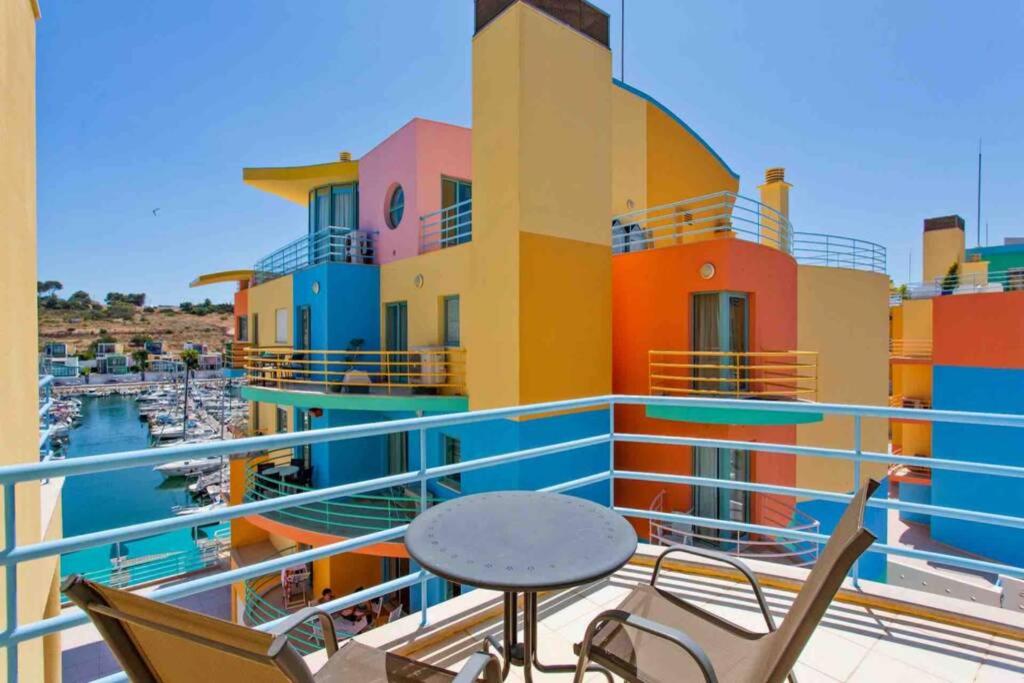 einen Balkon mit einem Tisch und Stühlen sowie einen Yachthafen in der Unterkunft Admirable 1 bedroom Marina view apt. Albufeira in Albufeira
