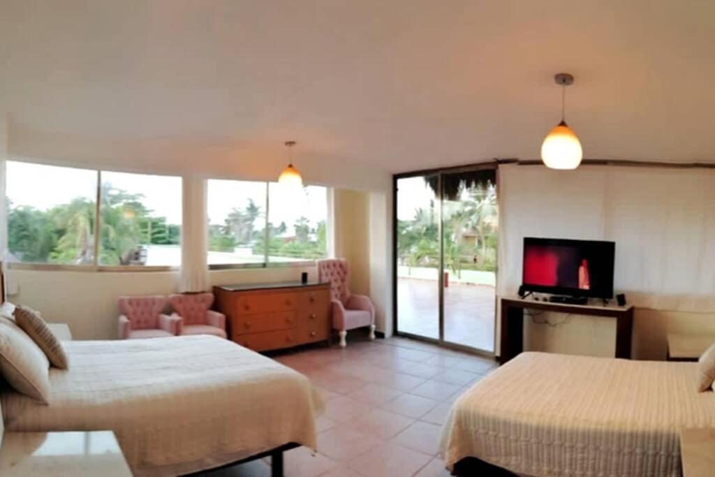 a hotel room with two beds and a television at Quinta Punta Sam in Cancún