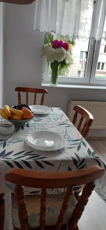 a table with plates and fruit on it with a window at Brzegiem morza in Gdańsk