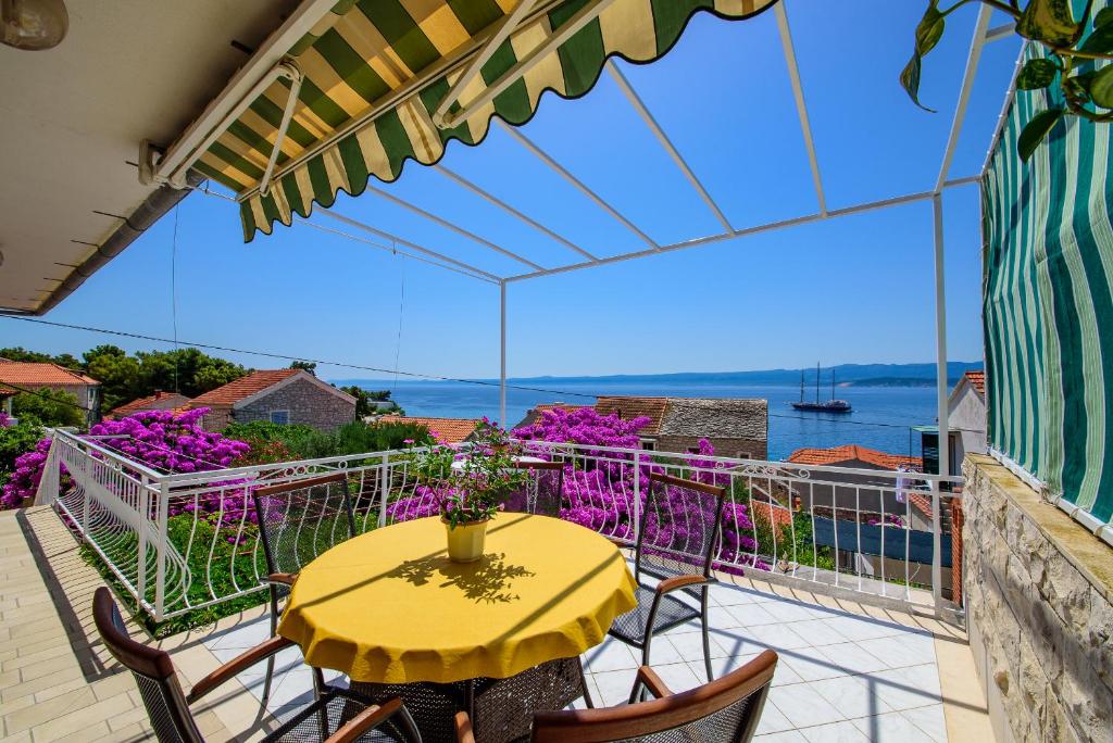 una mesa y sillas en un balcón con vistas al agua en Award winning Garden Apartment with large Terrace and amazing Seaview, en Bol