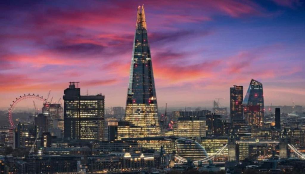 a skyline of a city with the shard at sunset at Tower Bridge LuxXe Nomads Lavish Choices for Large Groups House with Garden OR Penthouse with Skyline View - Free Parking in London