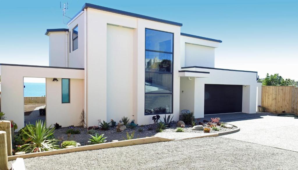 a white house with a lot of windows at Ātahu in Porirua