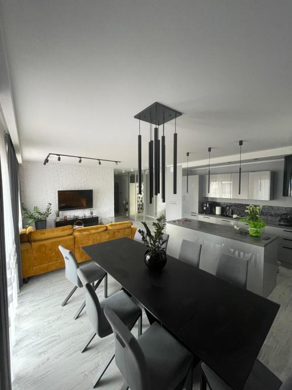 a kitchen with a black dining table and chairs at Solanki Apartament Solankowa Aleja Loft in Inowrocław