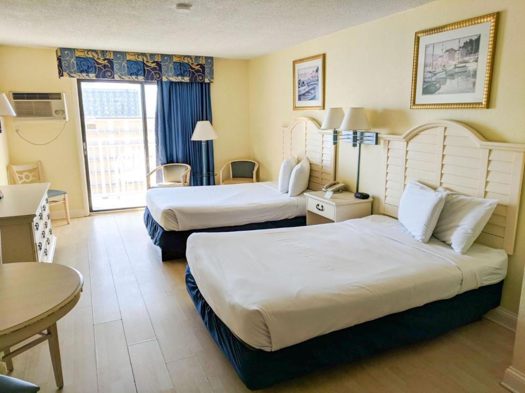 ein Hotelzimmer mit 2 Betten und einem Tisch in der Unterkunft Ocean view condo Sea Mist 50907 in Myrtle Beach