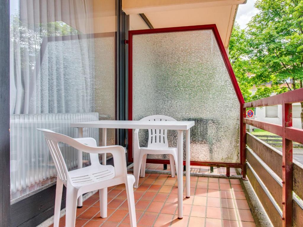 - une terrasse couverte avec 2 chaises, une table et une fenêtre dans l'établissement Apartment on the lakeside in Hahnenkle, à Hahnenklee