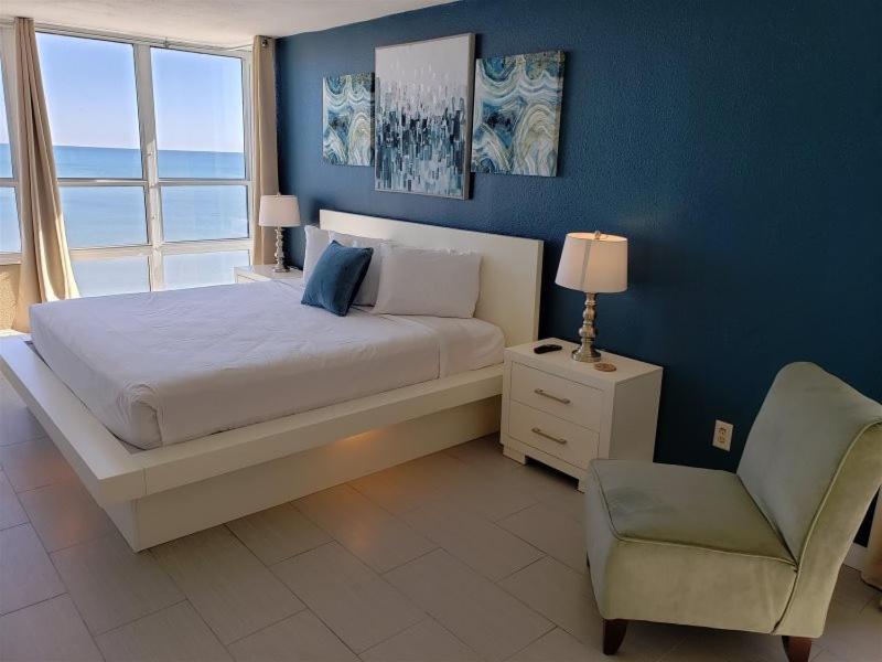 a bedroom with a bed and a chair and a window at Newly Renovated Beachfront Studio Sun N Sand 1014 in Myrtle Beach