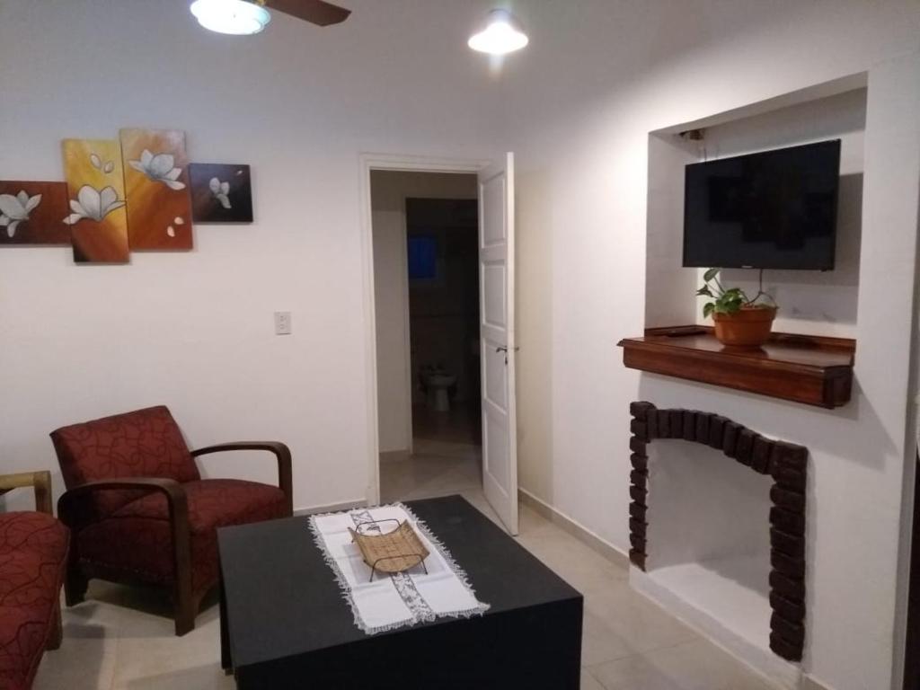 een woonkamer met een bank, een tafel en een tv bij Casa El Descanso in La Cumbre