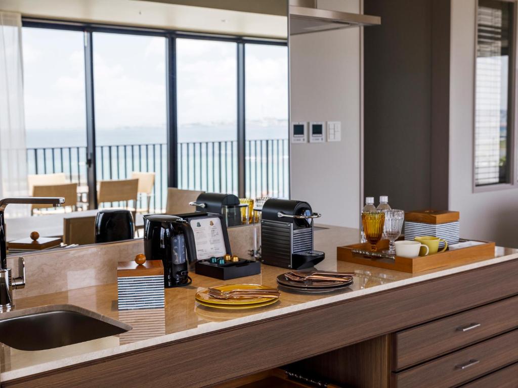 a kitchen with a counter with a sink and windows at MB GALLERY CHATAN by THE TERRACE HOTELS in Chatan