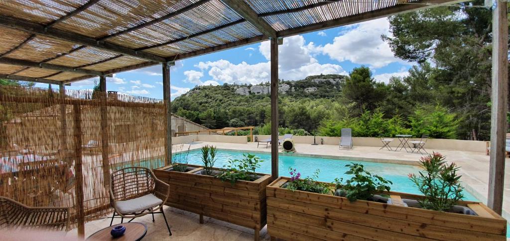 een patio met een stoel en uitzicht op een zwembad bij MAS DE LA FADETO in Les Baux-de-Provence