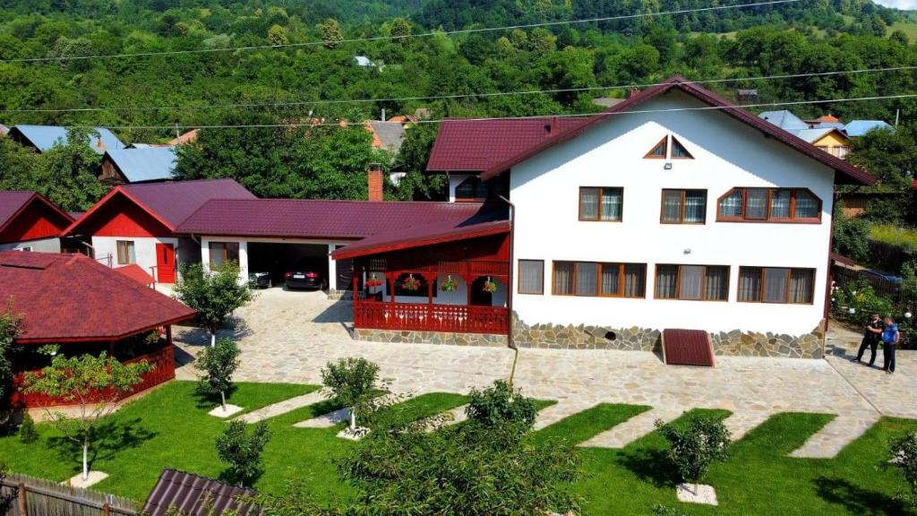 an aerial view of a white house and a red building at Casa Toader in Gura Teghii