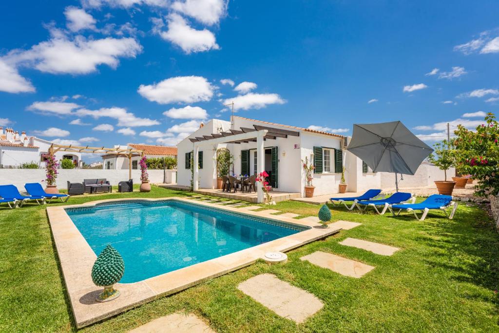 a villa with a swimming pool in a yard at Villa Forte in Cala'n Porter