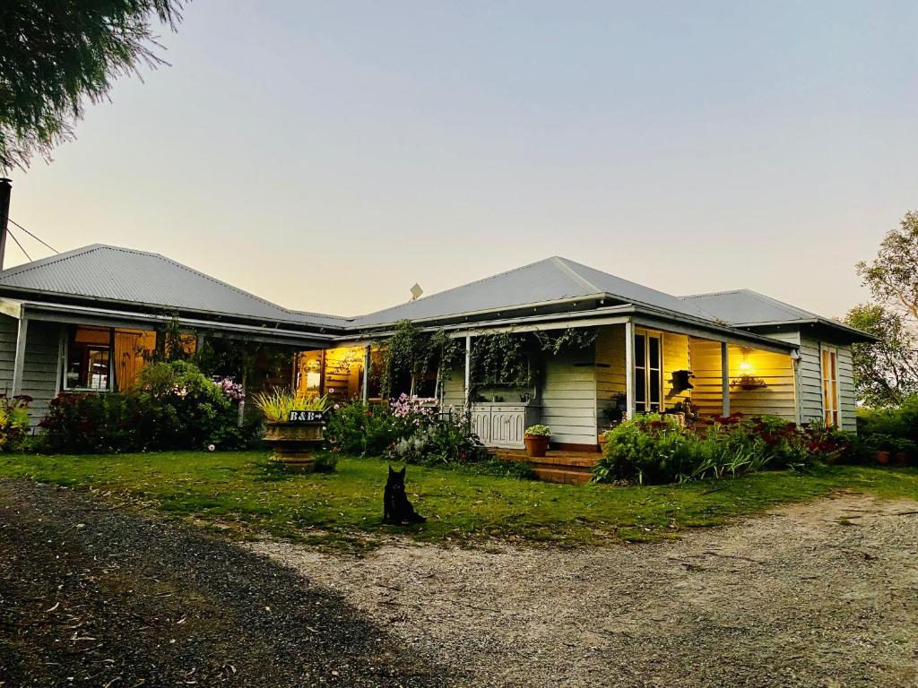 uma casa com um gato sentado no jardim da frente em Aashay Country Stay em Fish Creek