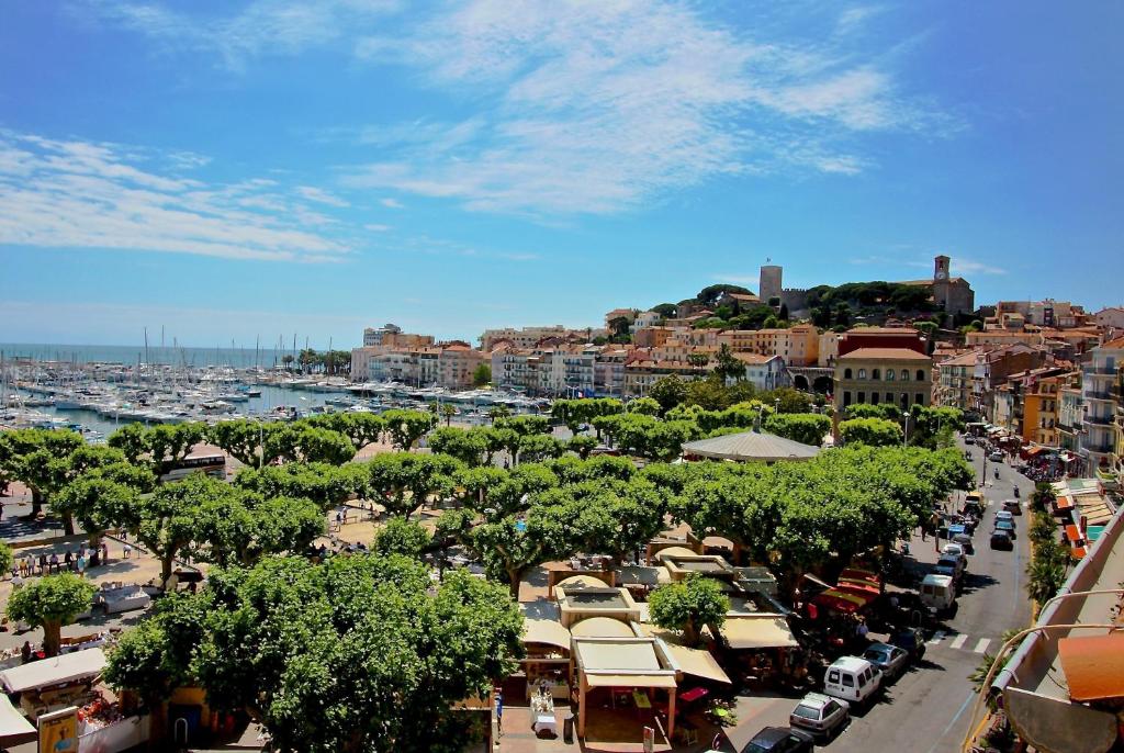une ville avec un port et une rue animée avec des voitures dans l'établissement Citilet 4 Duplex, funky with large terrace, à Cannes