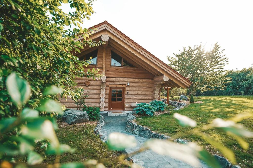 a log cabin with a pathway leading to the front door at Landhaus Auszeit in Grafengehaig