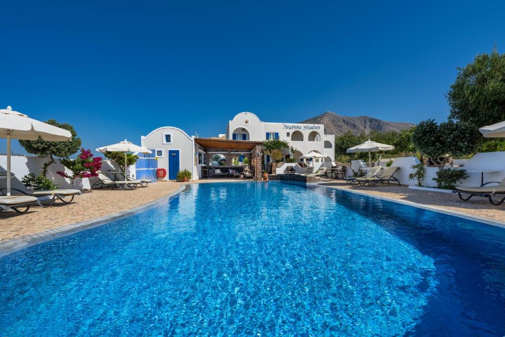 una piscina en un complejo con edificios blancos en Arapiou Apartments, en Perivolos