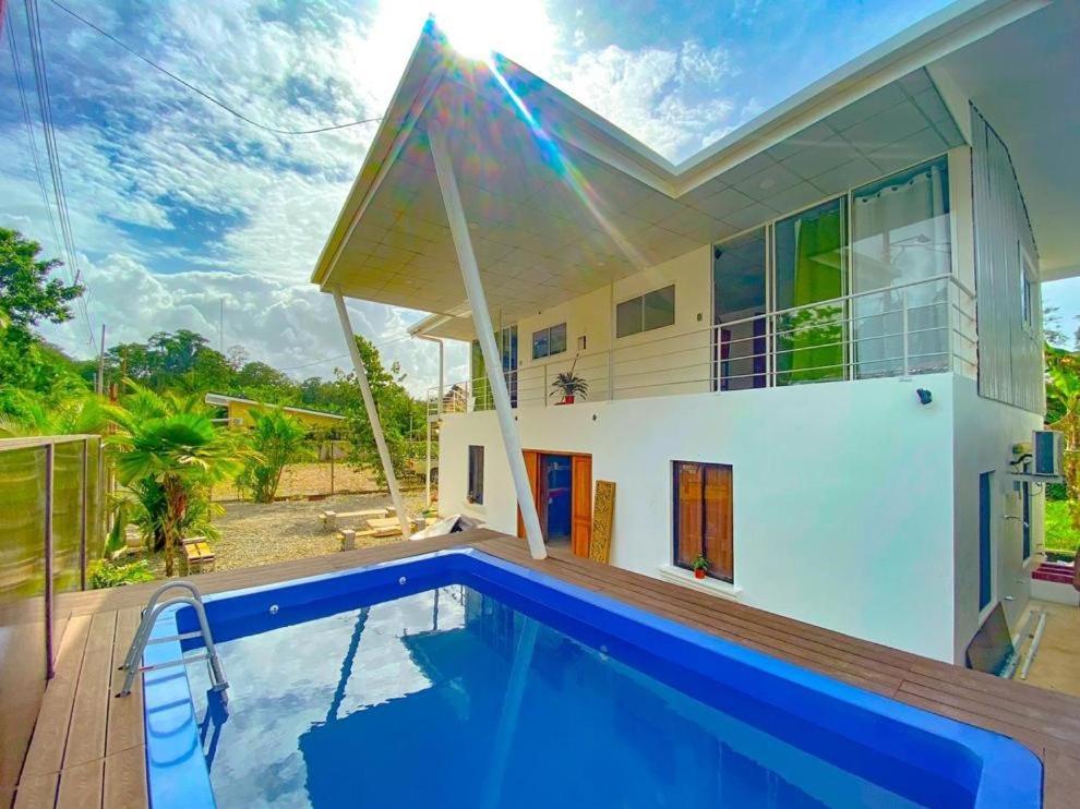 a villa with a swimming pool in front of a house at Puerto Viejo Lodge in Puerto Viejo