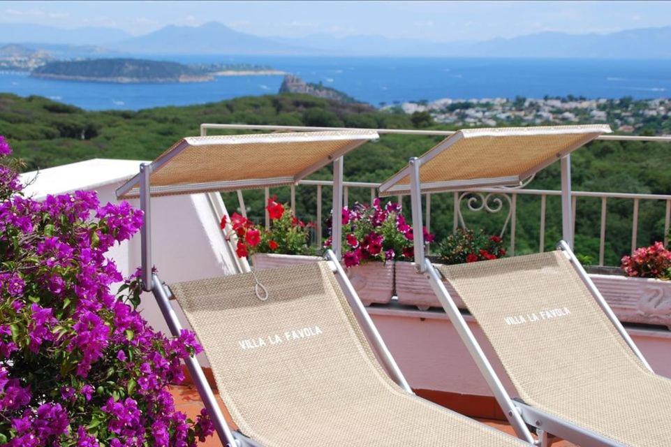 un par de sillas sentadas en un balcón con flores en Villa La Favola, en Isquia