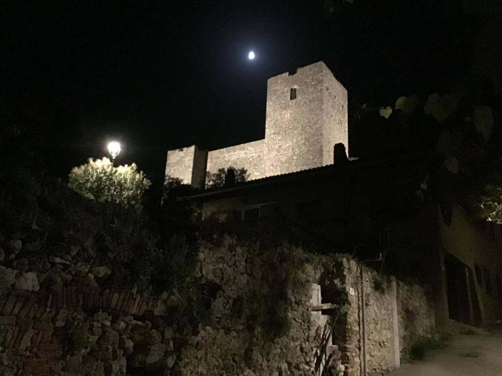 a building with a light on top of a wall at night at Casetta Terrosi in Talamone