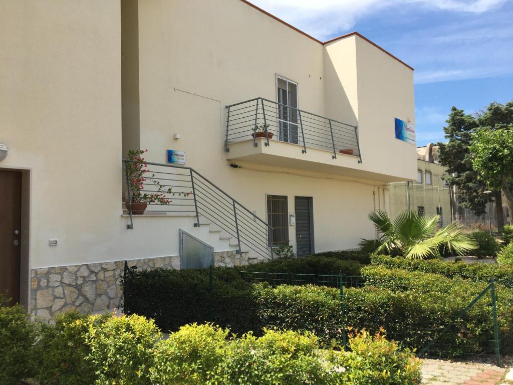a white building with stairs and a balcony at Pensione Afrodite in Metaponto