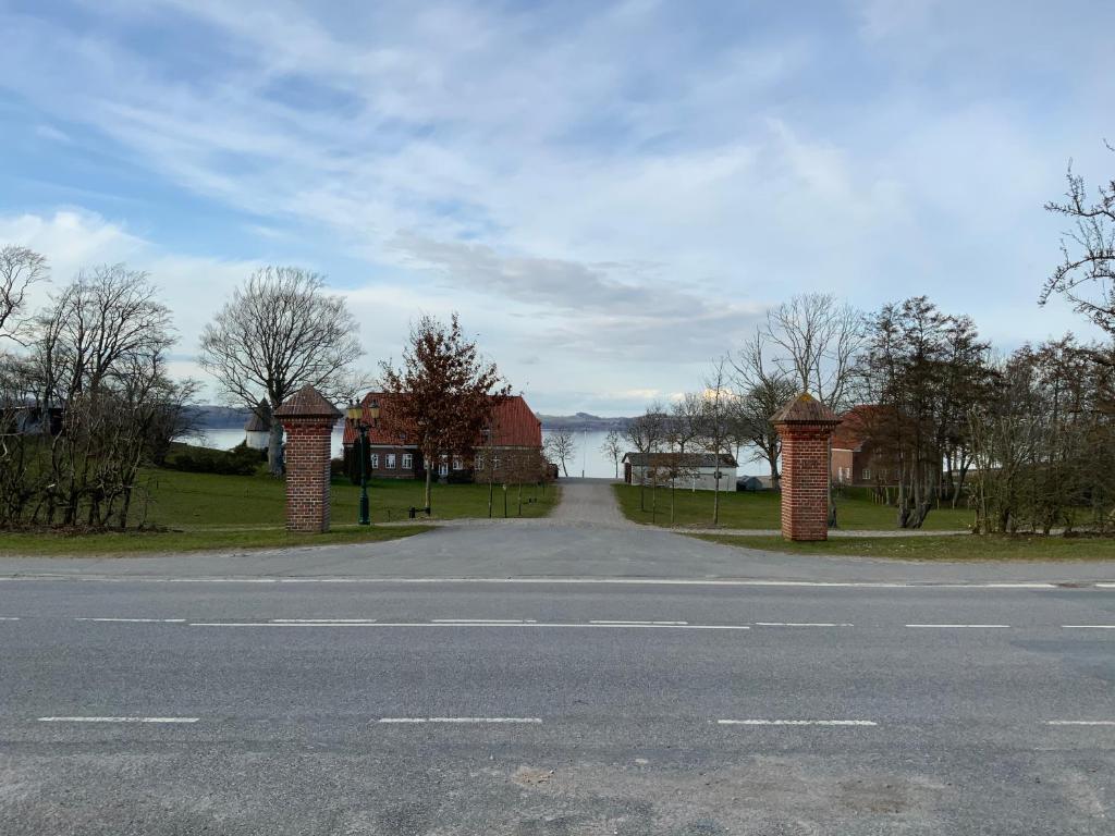 an empty road next to a house with a view of the water at Loff Holiday Houses in Aabenraa