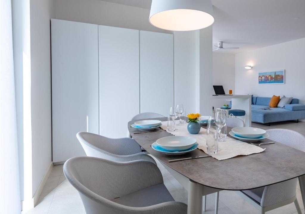 a dining room with a table and chairs at Pareus Beach Resort in Caorle