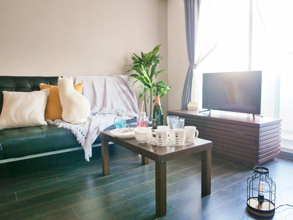 a living room with a green couch and a coffee table at Suncourt Maruyama Goden Hills / Vacation STAY 7605 in Sapporo