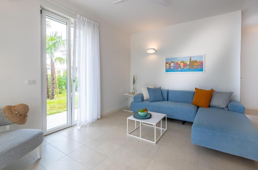 a living room with a blue couch and a table at Pareus Beach Resort in Caorle