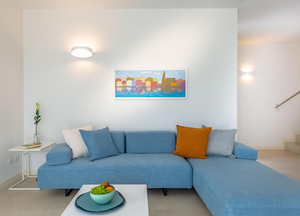 a blue couch in a living room with a table at Pareus Beach Resort in Caorle