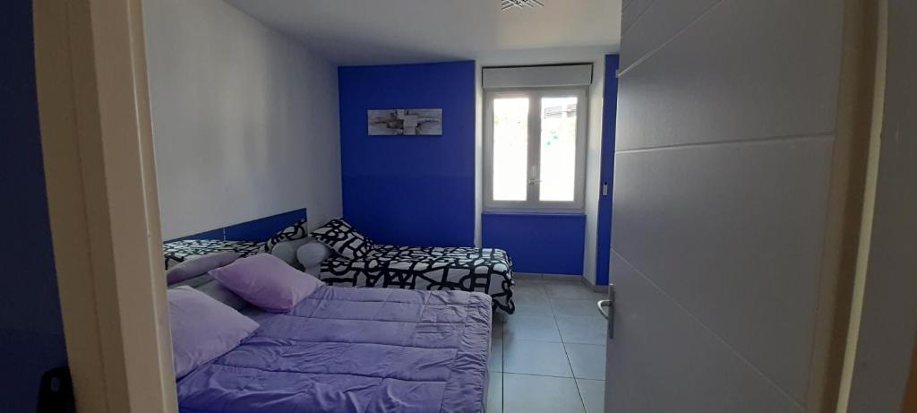 ein Wohnzimmer mit Sofa und blauen Wänden in der Unterkunft Au 70 in Millau