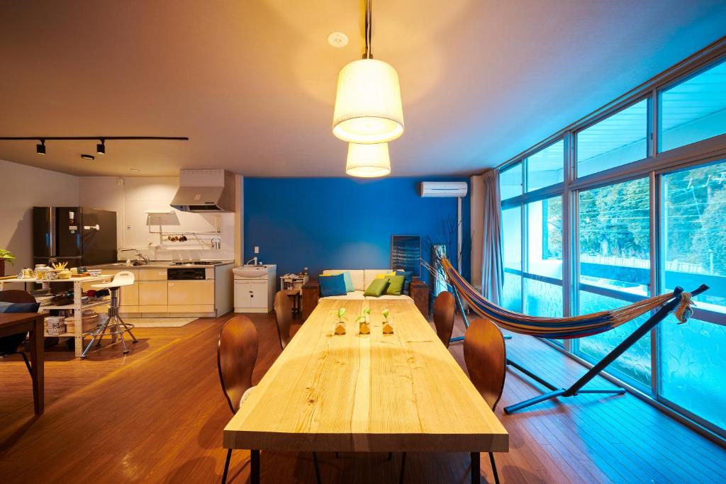 a dining room with a long wooden table and chairs at Hostel Coliberty in Tokushima