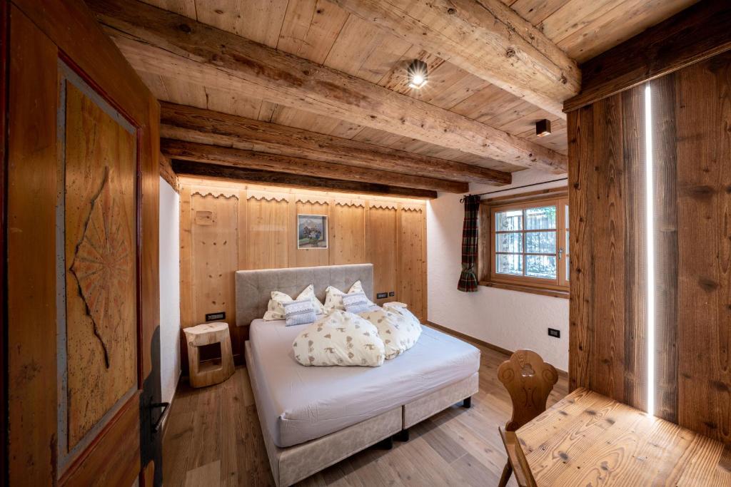 una camera con un letto in una stanza con pareti in legno di Camping Catinaccio Rosengarten a Pozza di Fassa
