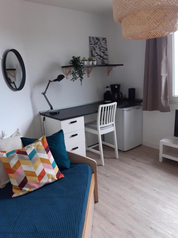 ein Wohnzimmer mit einem Schreibtisch und einem Sofa in der Unterkunft LE COCOON DE SAINT JEAN PROCHE CLINIQUE DE L UNION in Saint-Jean