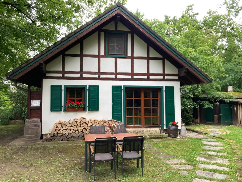 une maison avec une table et des chaises devant elle dans l'établissement Haus am Wald, à Rudolstadt