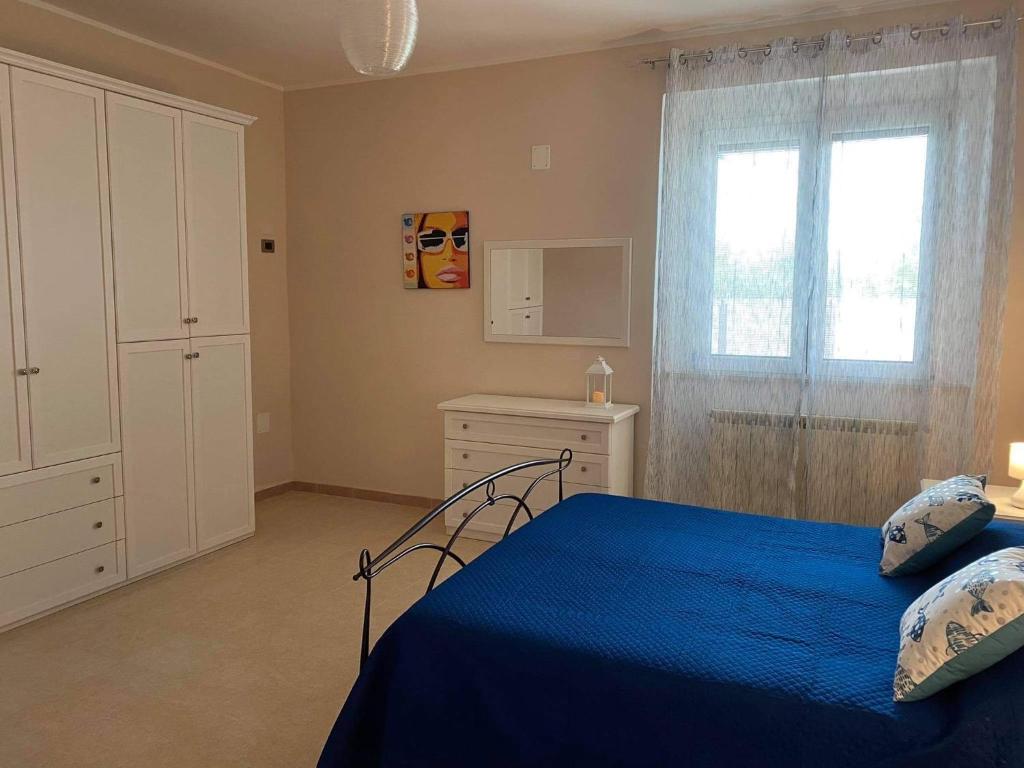 Un dormitorio con una cama azul y una ventana en Villa Baccile en Fossacesia