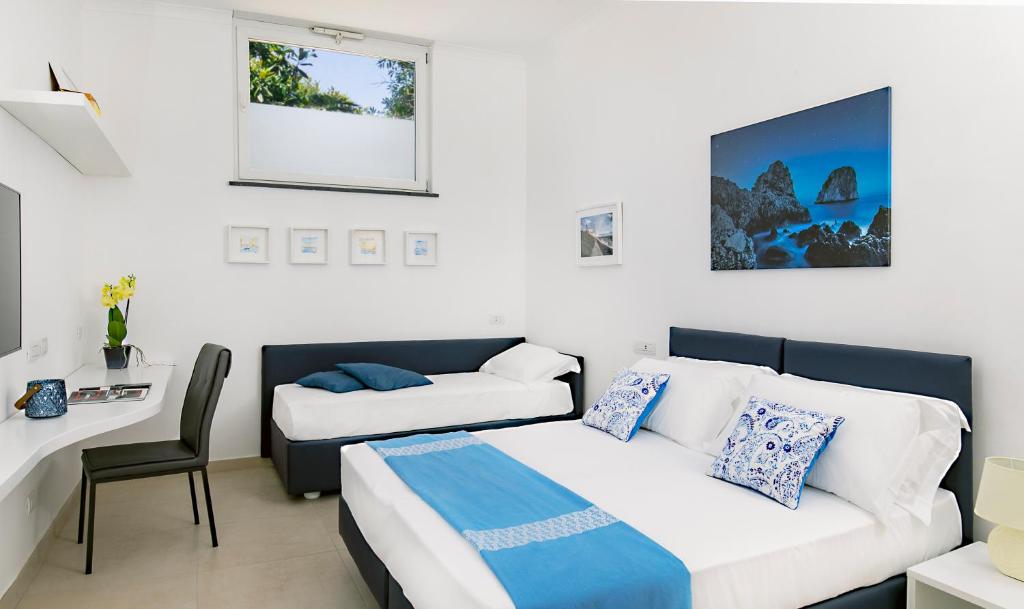 - une chambre avec un lit, un canapé et un bureau dans l'établissement Casetta Caprile, à Anacapri