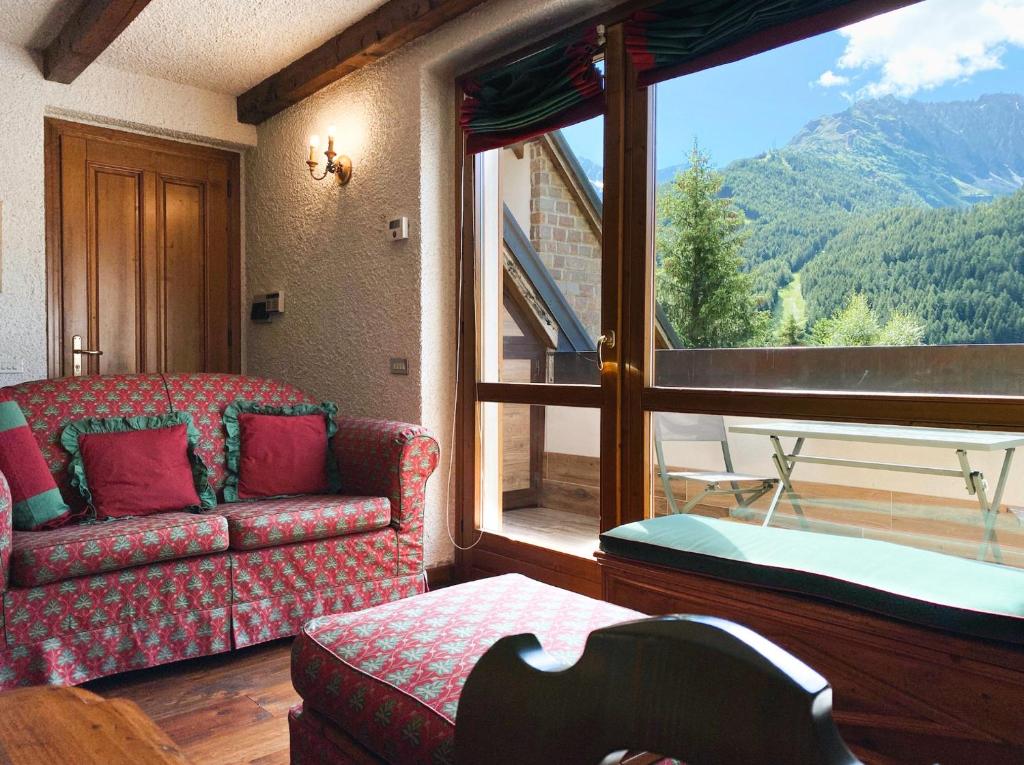 a living room with a couch and a large window at Betulla House - AffittiPontediLegno in Ponte di Legno