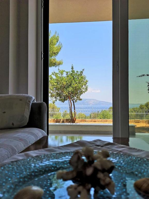a living room with a couch and a large window at Panorama View Apartment 2 in Áyioi Apóstoloi