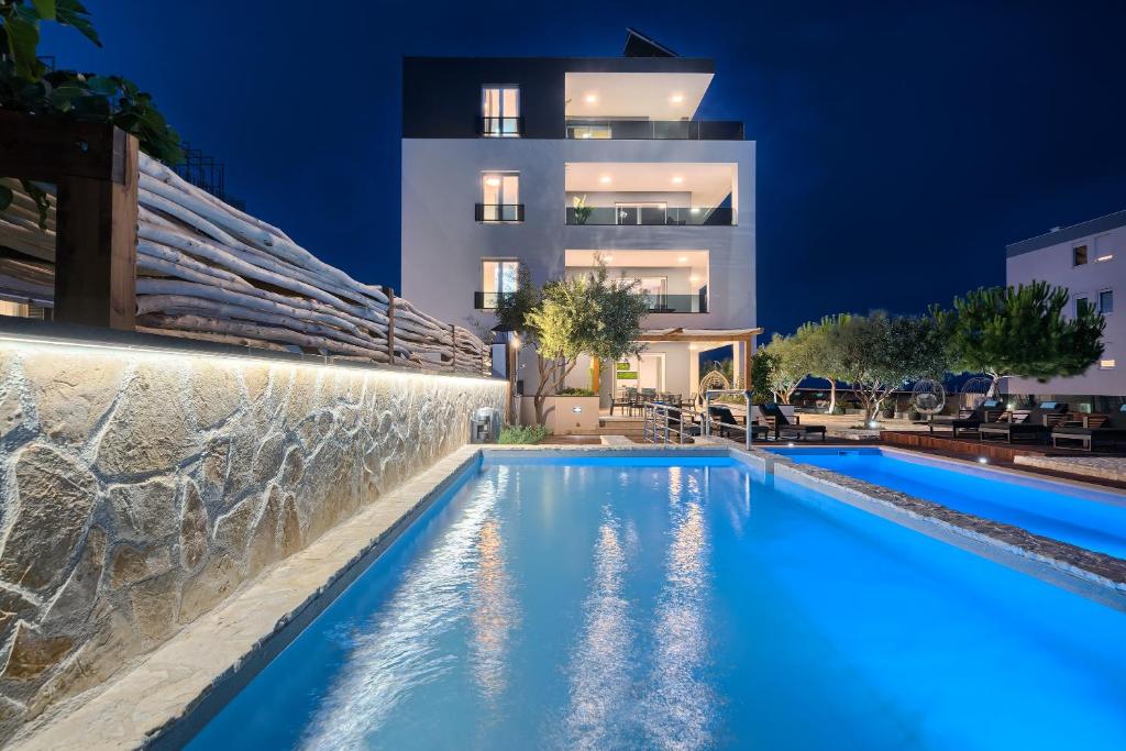 Villa con piscina por la noche en Liberty Living Apartments en Split