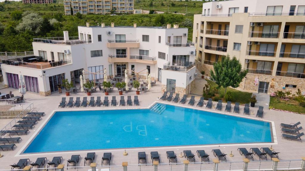 - une vue sur la piscine en face des bâtiments dans l'établissement Byala Panorama Resort, à Byala