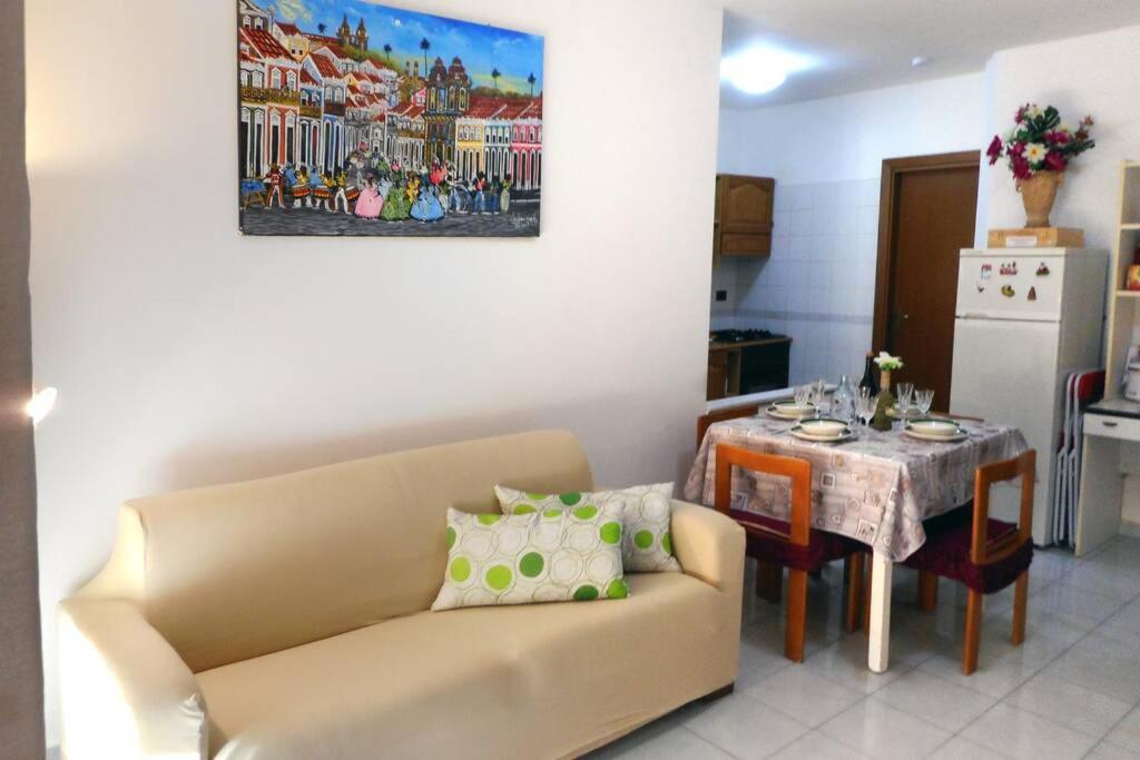 ein Wohnzimmer mit einem Sofa und einem Tisch in der Unterkunft Casa Bahia in Marina di Davoli
