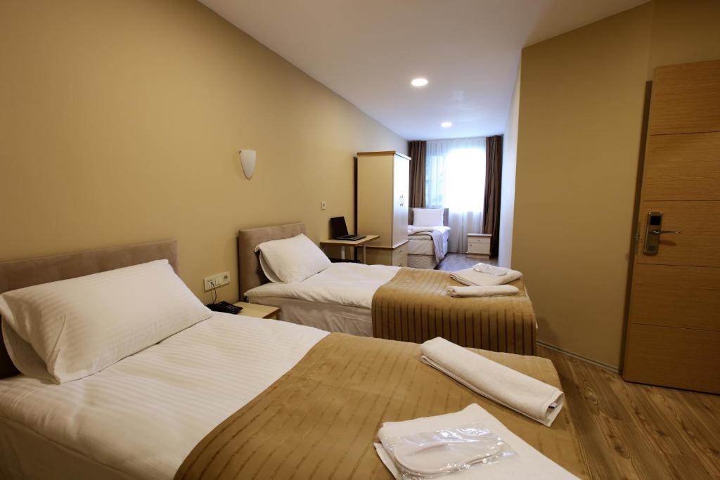 una camera d'albergo con 2 letti e una scrivania di The Marist Hotel Kadikoy a Istanbul
