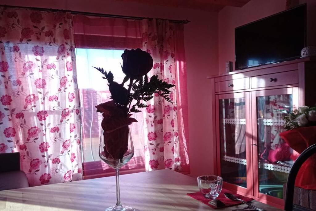 un vase de fleurs assis sur une table avec une fenêtre dans l'établissement Happy Home Hosting, à Rieti