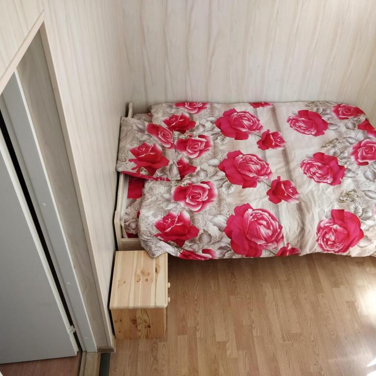 a bedroom with a bed with red roses on it at Kanepi accommodation One room in Viljandi