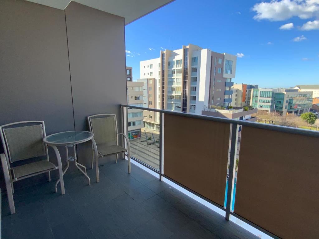 
a balcony overlooking a city with a view of the ocean at Honeysuckle Executive Apartments in Newcastle
