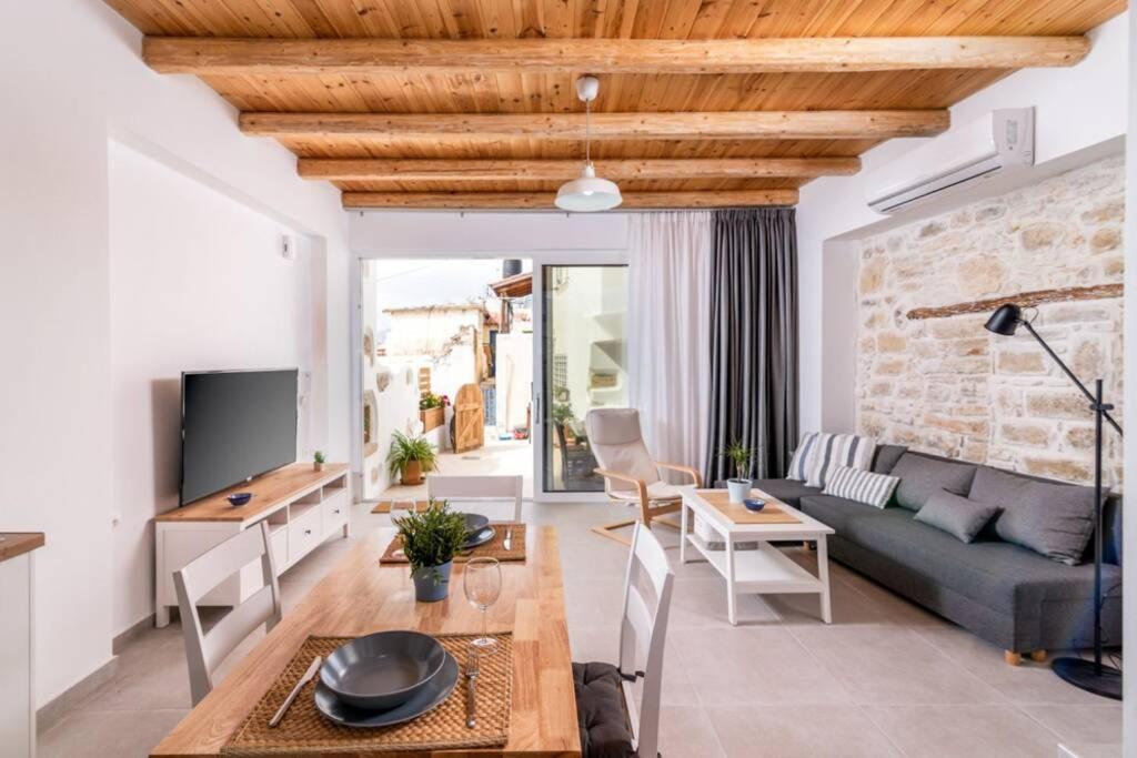 Maisonnette Giannis في بيتسيديا: غرفة معيشة مع أريكة وطاولة