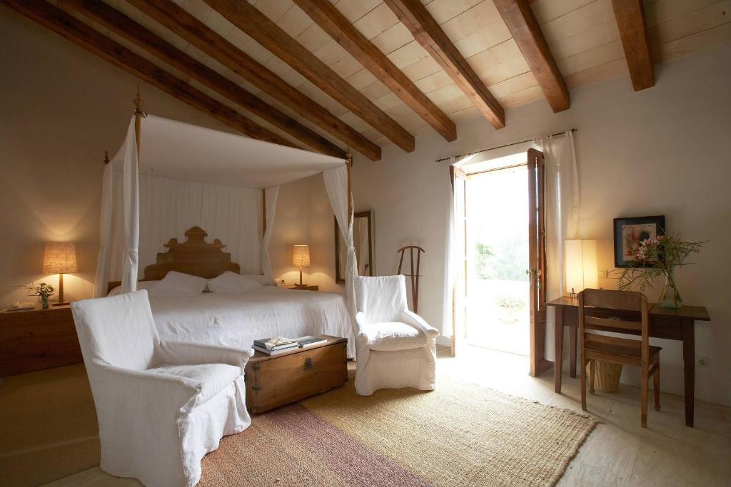 a bedroom with a bed and a chair and a window at Son Gener Hotel Spa in Son Servera