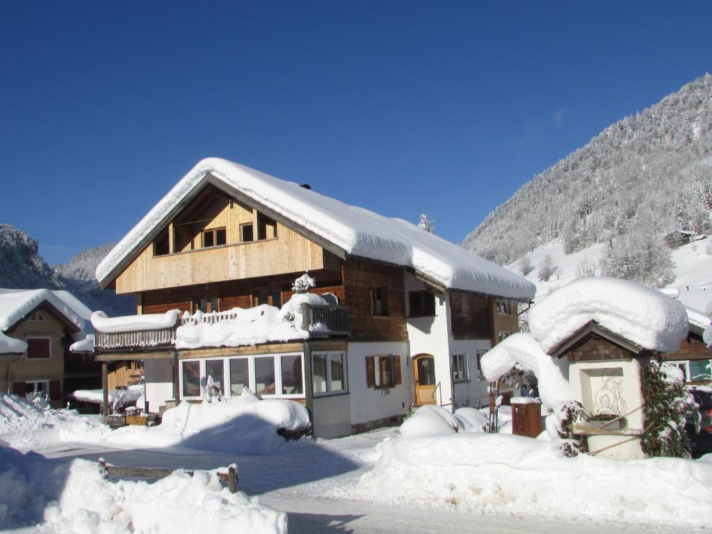 a large building covered in snow with mountains in the background at CHALET 294 in Mellau