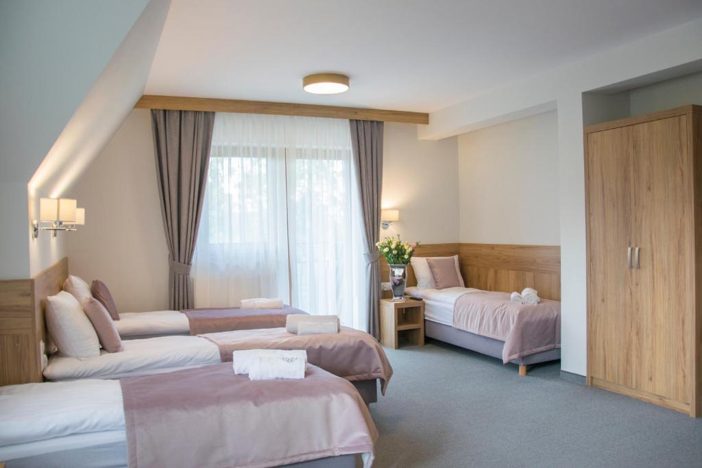 a hotel room with two beds and a window at Ośrodek Wypoczynkowy Molanda in Biały Dunajec